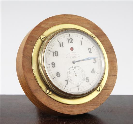 A 1920s motoring timepiece, diam. 4.25in, in a later wooden mount